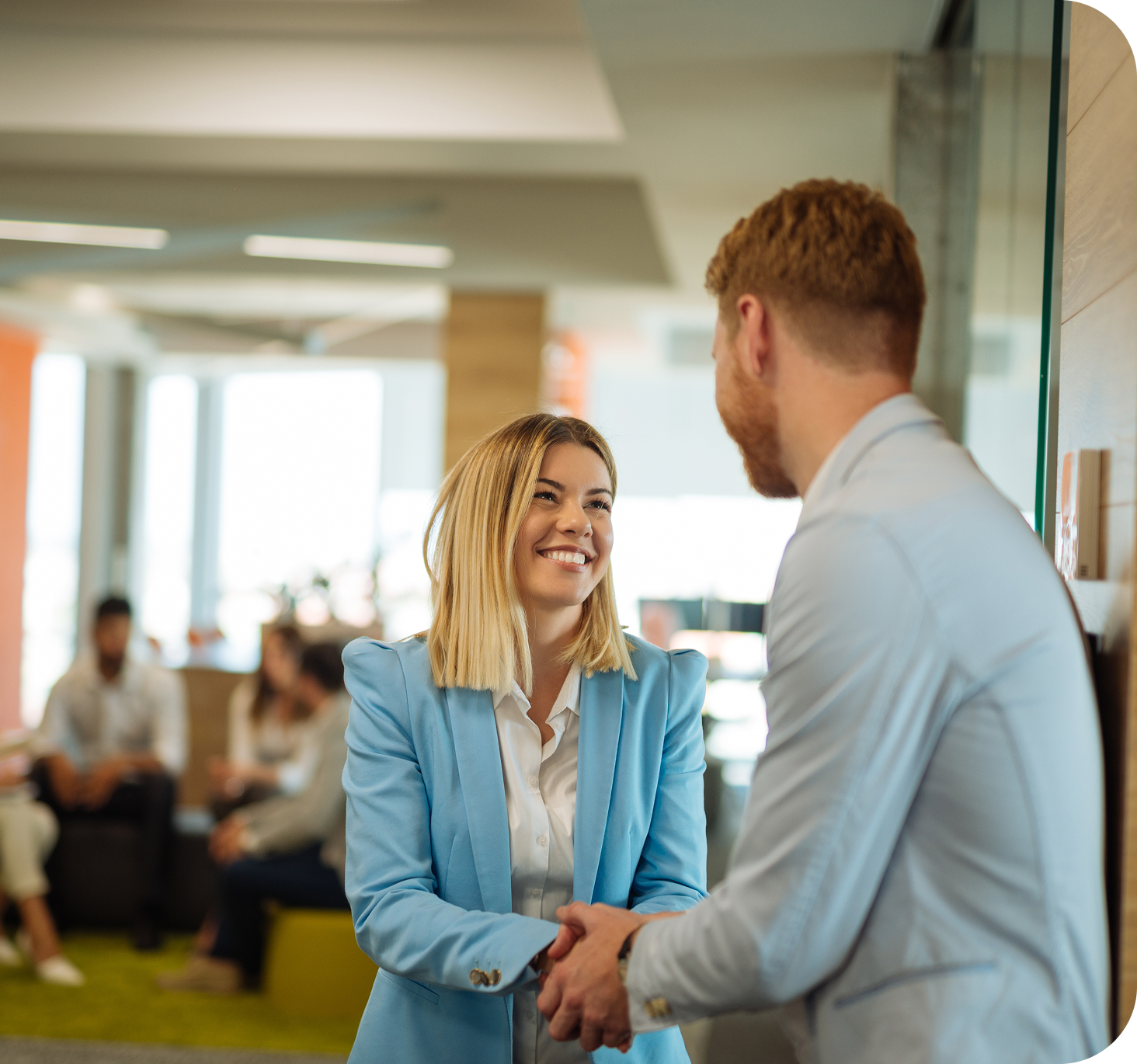 Two colleagues shaking hands in a modern office, representing company values