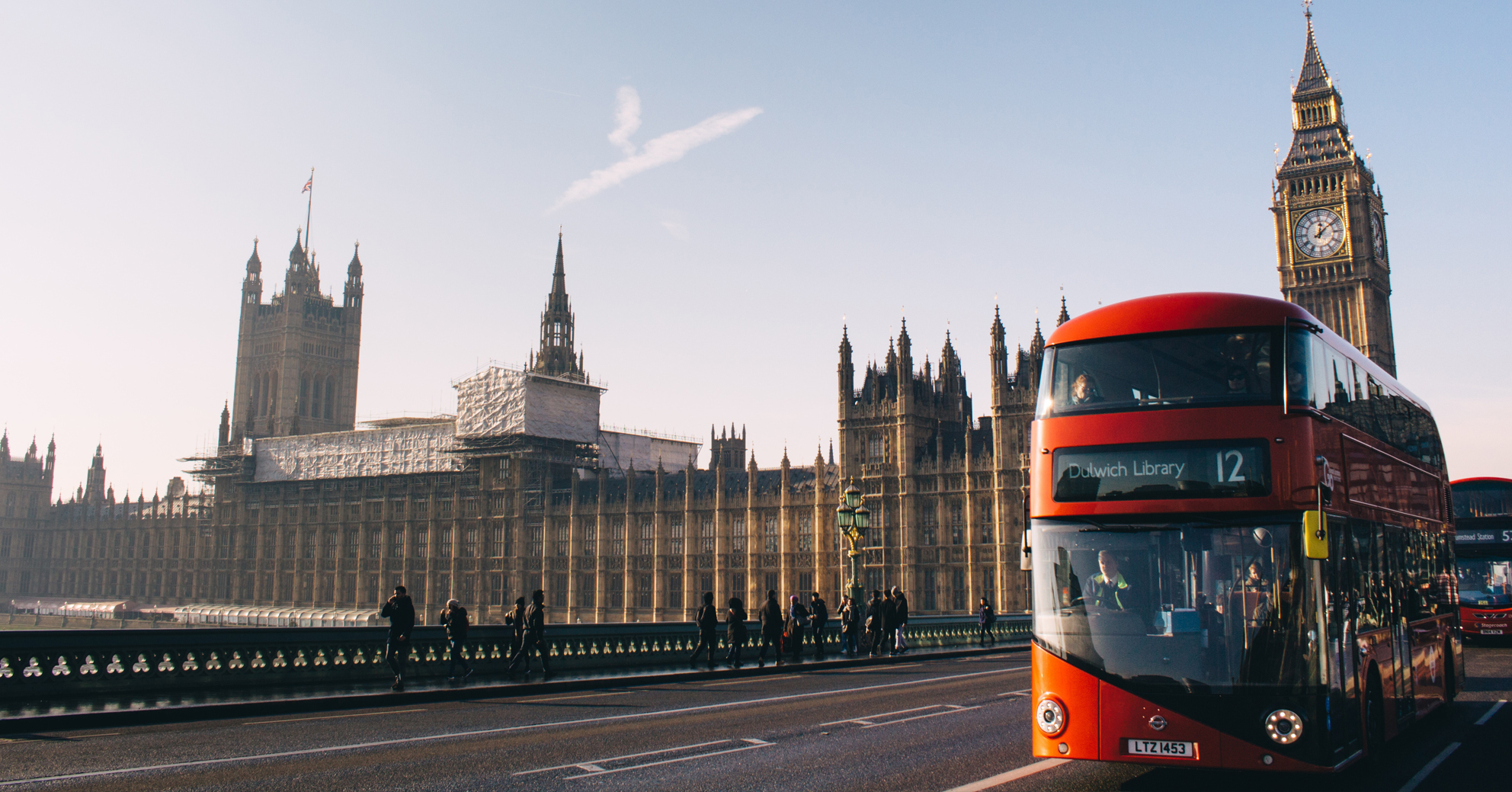 An image of London. A red-double decker bus in Westminster. The Houses of Parliament and Big Ben are in the background. Check your National Insurance Contributions Record