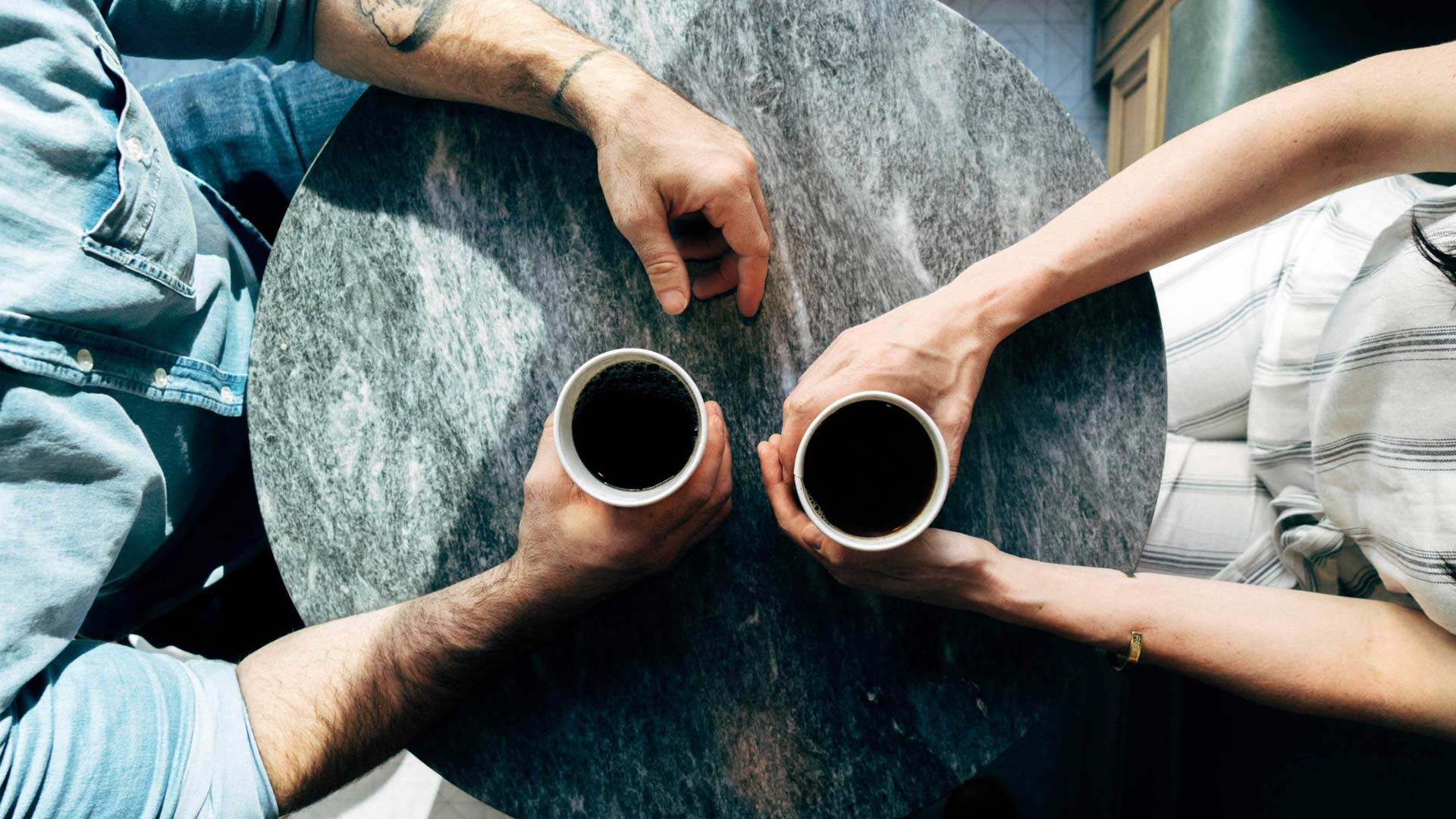 An image of a couple of people having a conversation with cups of coffee. Will writing and talking to your loved ones