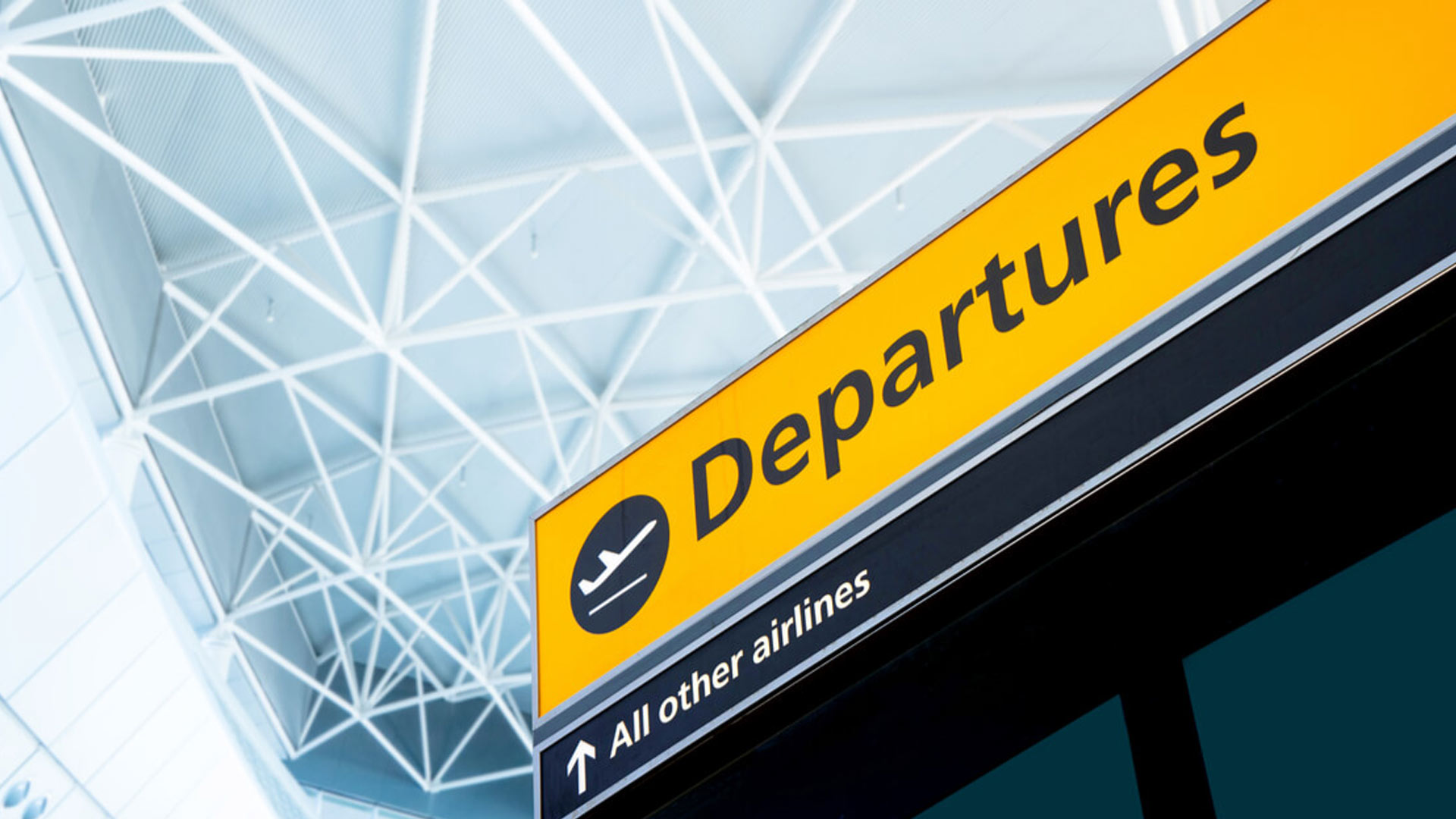 An image of a yellow airport Departures sign. Common mistakes first time expats make