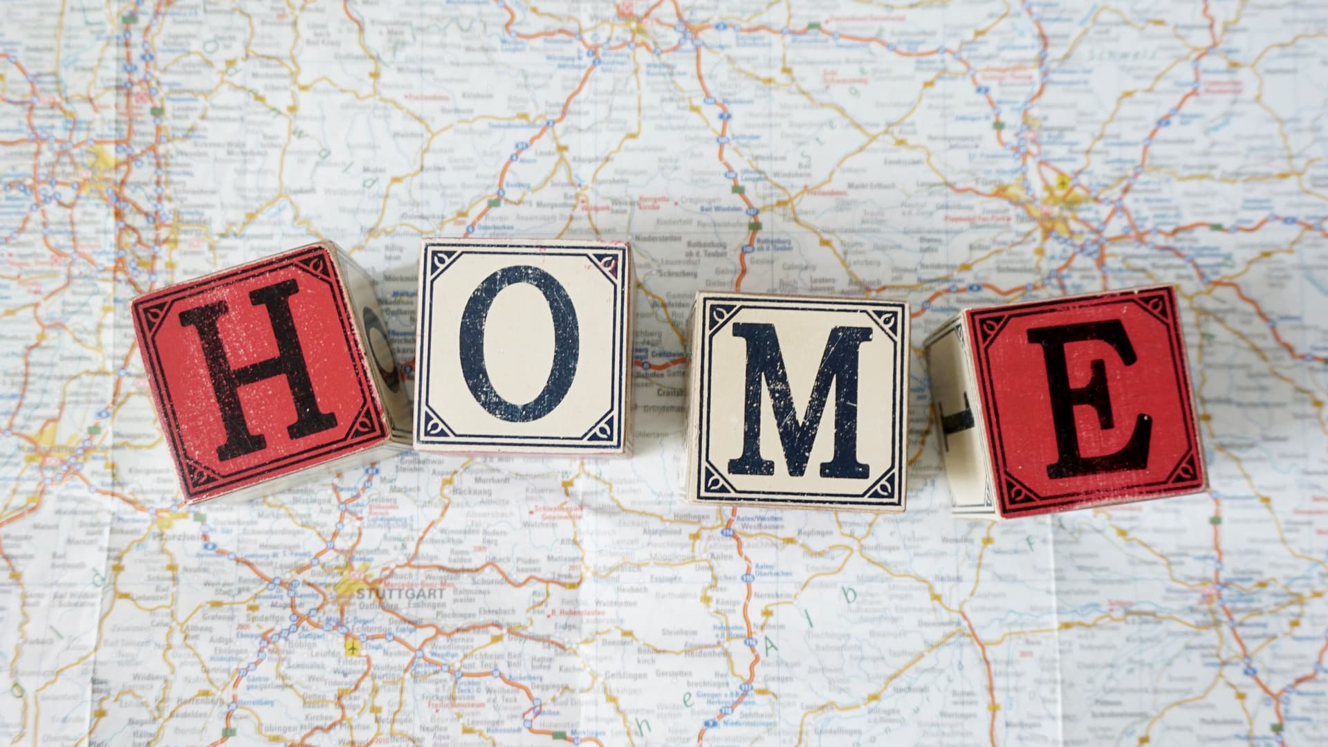 An image of a map with wooden letters forming the word HOME on top of it. Returning UK citizens - what to know