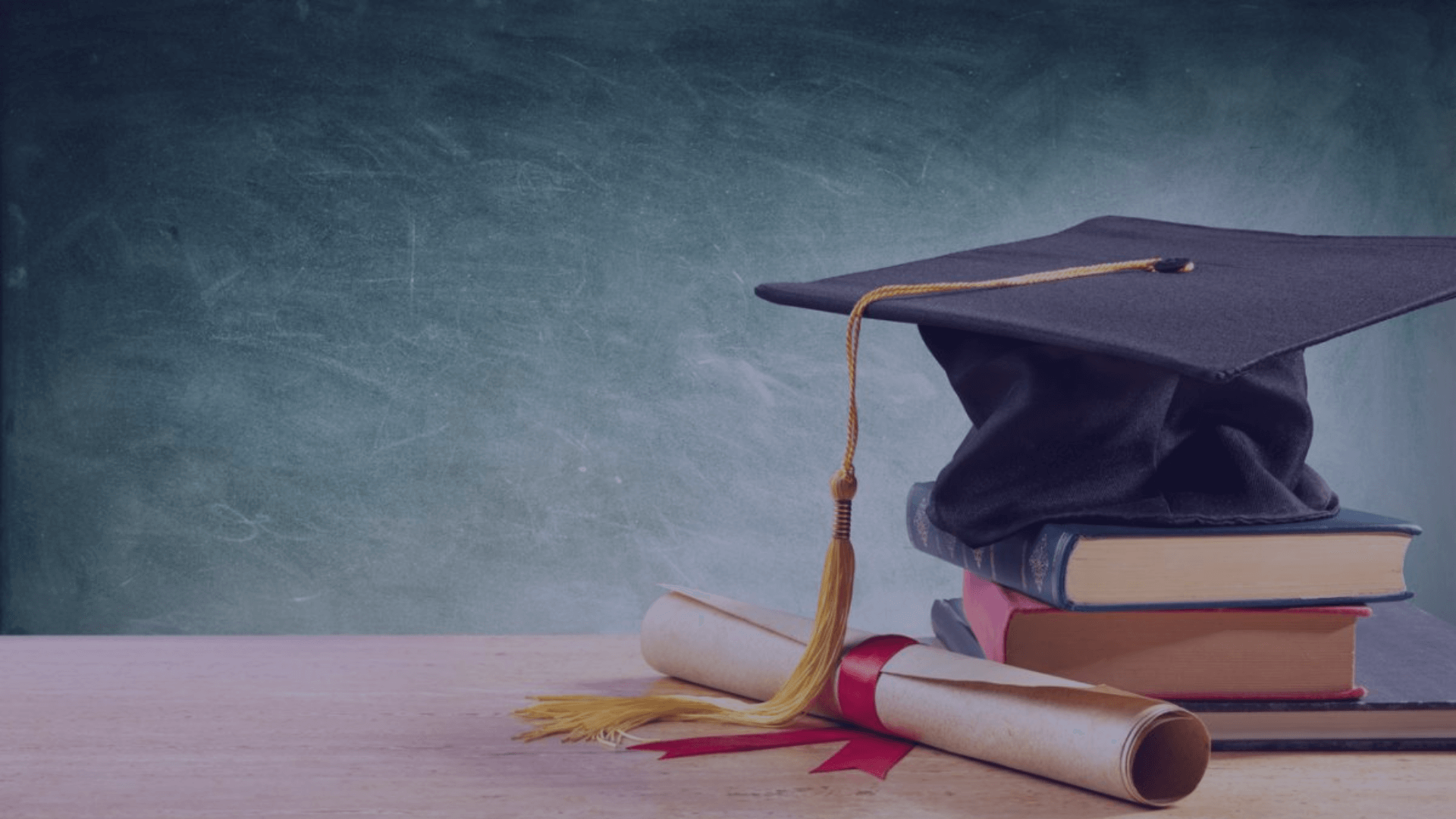 An image of the mortarboard, a hat worn at university graduations. A hat is placed on the pile of books and a university diploma is next to it. Education planning and benefits you need to know