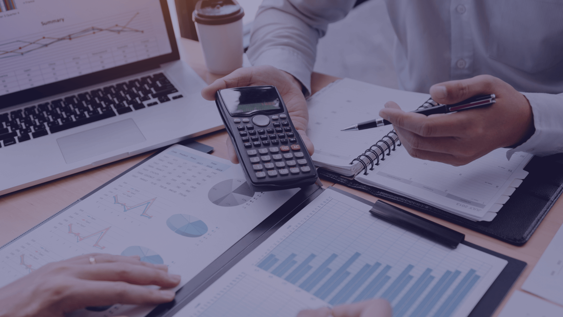 An image of a laptop displaying different graphs. A person is holding a pen and a calculator and has a planner open in front of them. Financial Planning Mistakes Made by Millennials