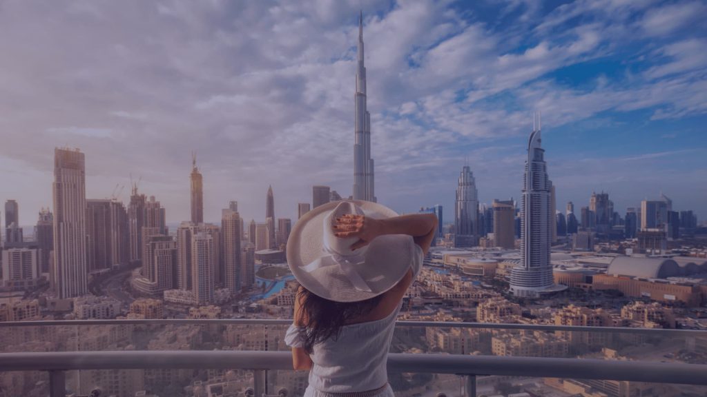 A woman wearing a summer hat admiring a view of Dubai. All you need to know about moving to Dubai