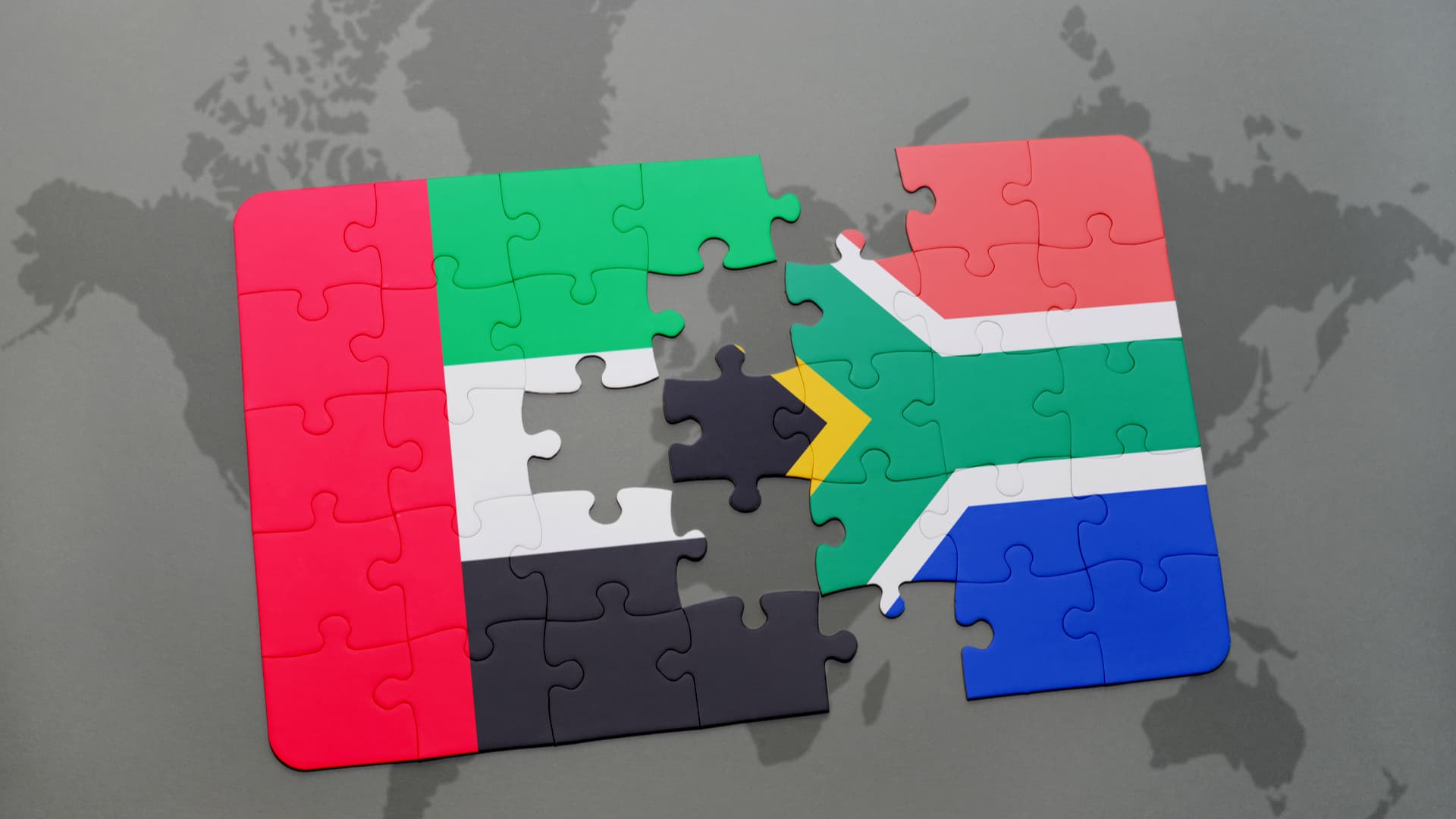 An image of the map of the world with the jigsaw puzzle of the South African flag being assembled on top of it. Moving to the UAE from South Africa