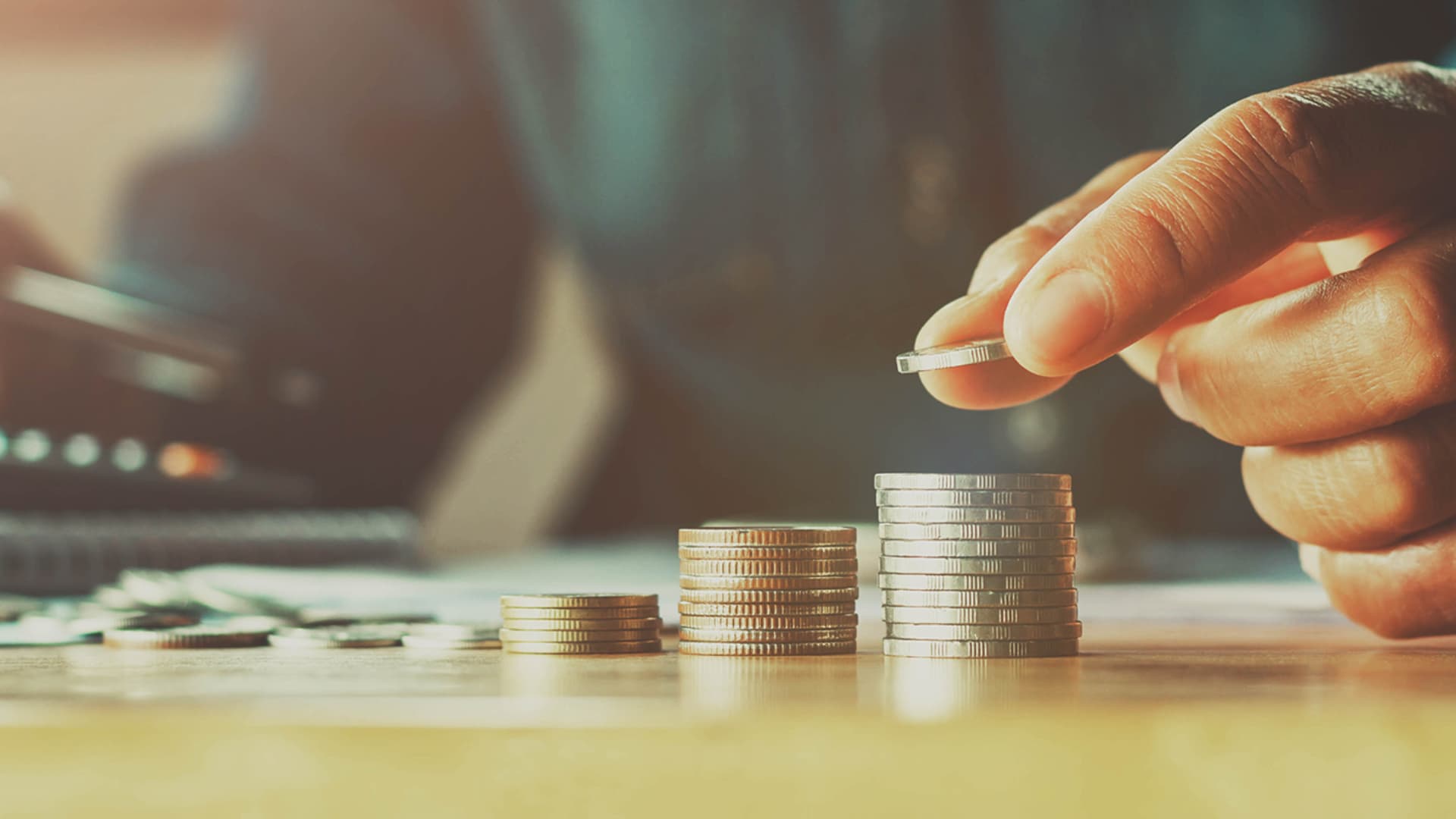 An image of a person building stacks of coins. Ways to grow your savings