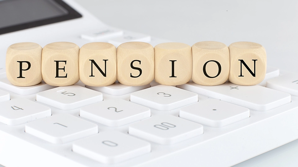 Wooden cubes with text PENSION on the calculator | Defined Benefit Pensions